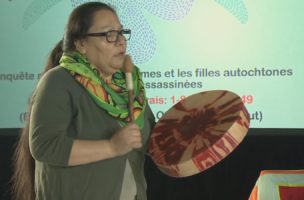 Femme jouant du tambour lors des audiences de l' Enquête nationale sur les femmes et les filles autochtones disparues et assassinées.